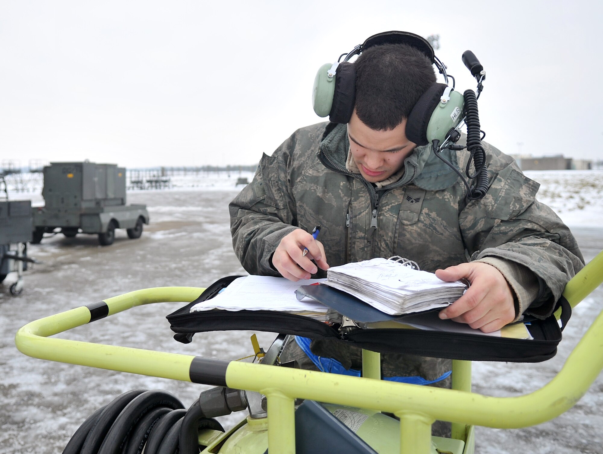 Senior Airman Spencer Lujan, 100th Aircraft Maintenance Squadron crew chief from St. Peters, Mo., documents tasks performed on the flightline Jan. 23, 2013, at RAF Mildenhall, England. Prior to each mission, crew chiefs and other maintenance personnel work together to ensure aircraft are safe and ready to go. (U.S. Air Force photo by Senior Airman Jerilyn Quintanilla/Released)  