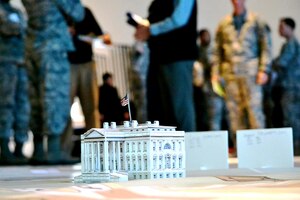A group of Presidential Inauguration Committee members huddle around a model of the White House during a committee meeting, Jan. 3.  The 53rd Movement Control Battalion, 7th Sustainment Brigade, leads a team of hundreds of Service members as they take command and control of parade floats, participants, parade transportation and route safety during the 57th Presidential Inauguration Jan. 21. (U.S. Army photo by Sgt. Edwin J. Rodriguez/Released)