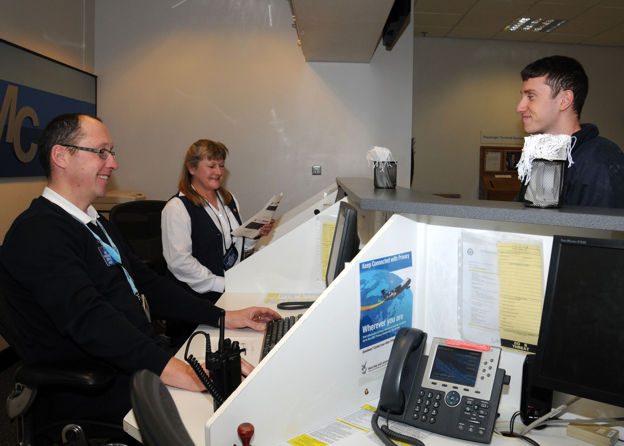 From left, Jonathan Coomber and Janet McCormack, both 727th Air Mobility Squadron passenger service agents, assist a customer with an enquiry at the passenger service counter Jan. 23, 2013, at the RAF Mildenhall Passenger Terminal, England. The terminal offers military members and their dependents, as well as retirees, space available travel. (U.S. Air Force photo by Gina Randall/Released)
