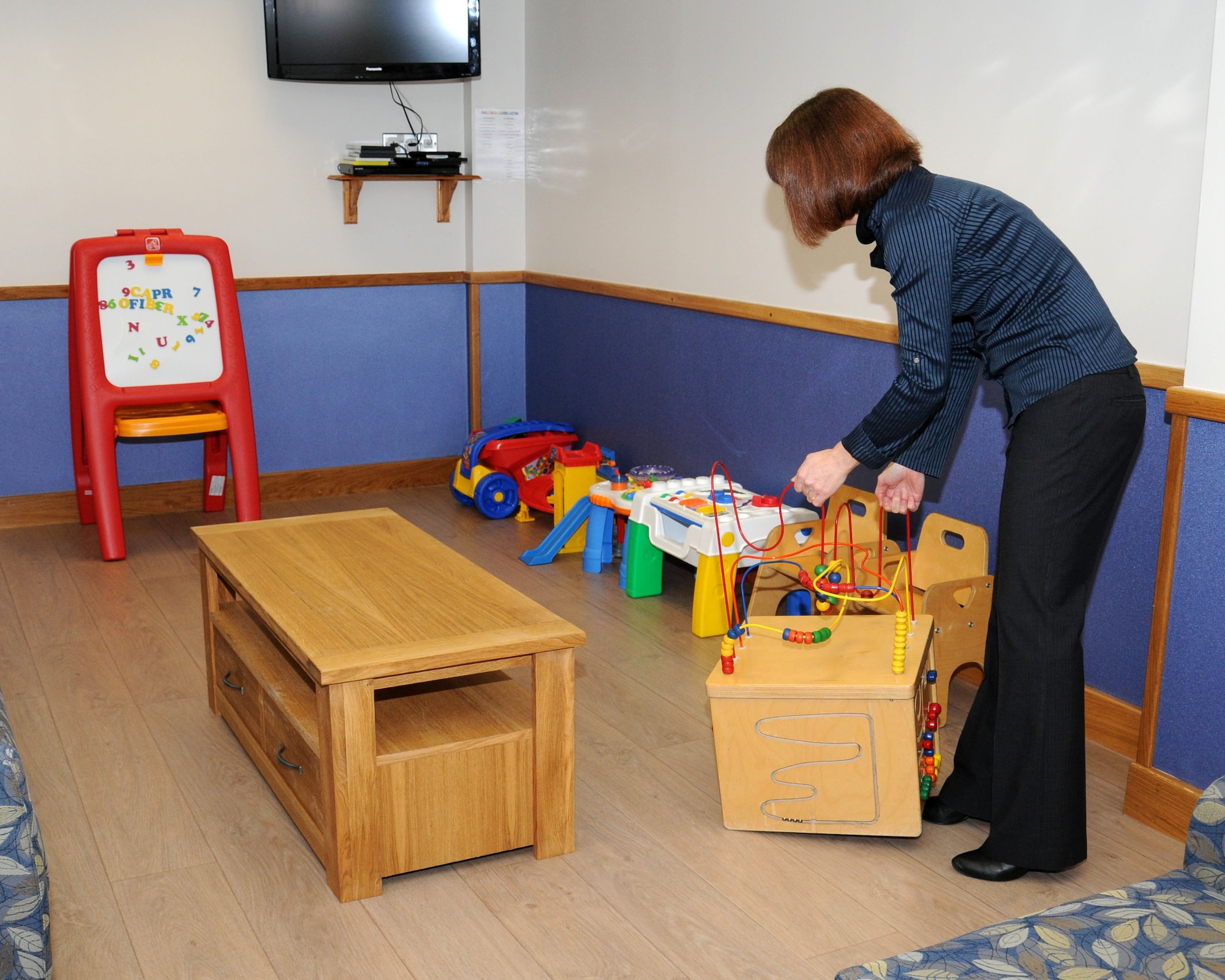 Elaine Dawson, 727th Air Mobility Squadron passenger terminal manager, arranges toys in the family room Jan. 23, 2013, at the RAF Mildenhall Passenger Terminal, England. The family room was reopened in March 2012 following a complete refurbishment and it provides entertainment for children while their families wait for flights. (U.S. Air Force photo by Gina Randall/Released)