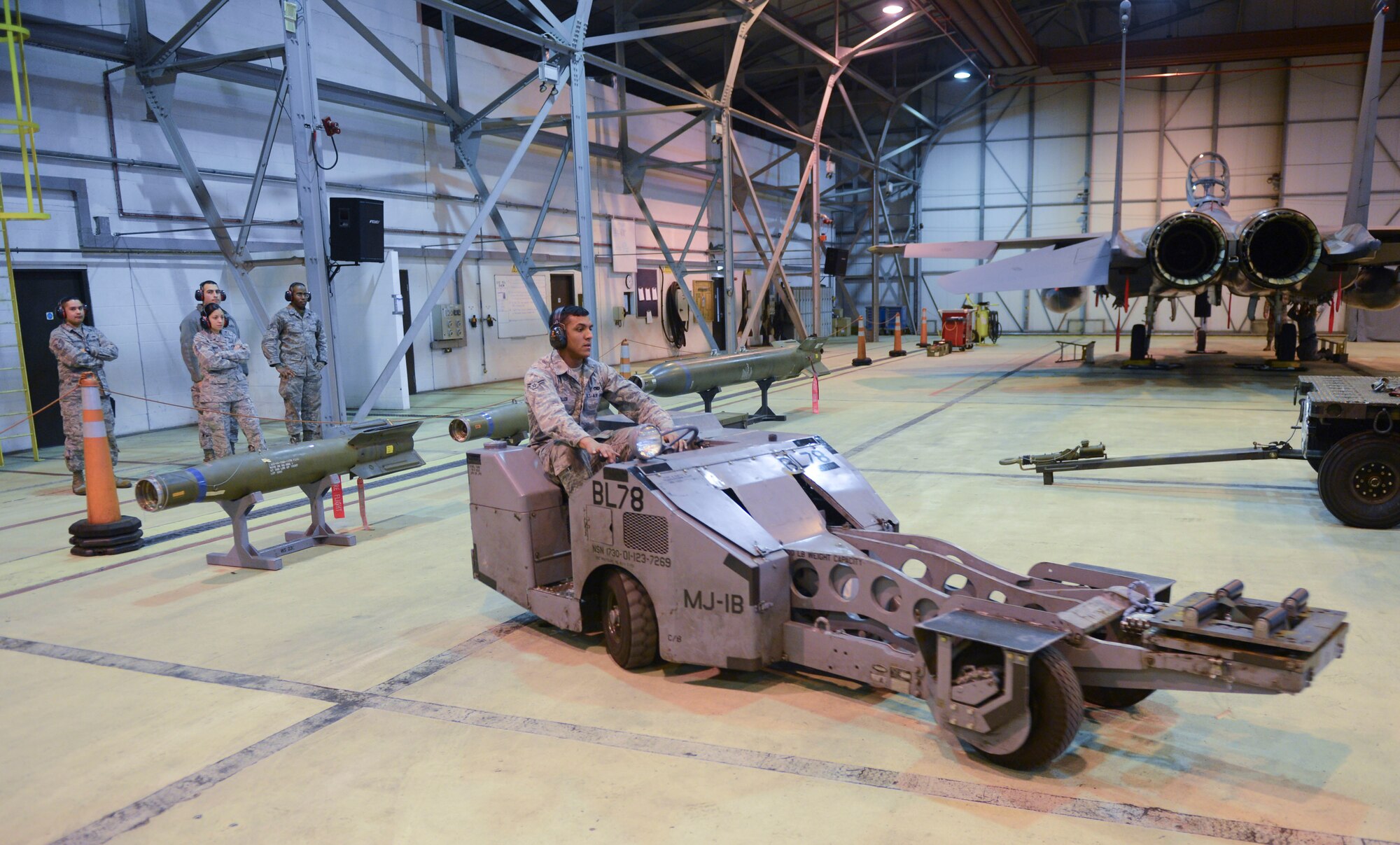 ROYAL AIR FORCE LAKENHEATH, England - Maintainer for a Day participants watch as Airman 1st Class Jordan Fuller, 48th Maintenance Operation Squadron weapons load crew member and native of Burnsville, Minn., drives an MJ-1, a vehicle specially made to load munitions, during a weapons load Jan. 18, 2013. The Maintainer for a Day program allowed Airmen who work in units other than the 48th Maintenance Group to experience what it is like to be an aircraft maintainer. (U.S. Air Force photo by Staff Sgt. Stephen Linch)