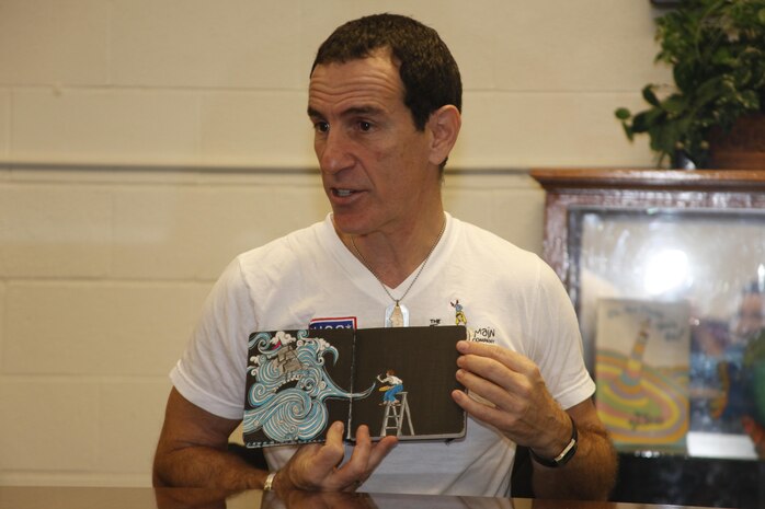 Trevor Romain, a motivational speaker for children, shows children of Arthur Edwards Elementary School in Havelock, N.C., his drawing book, saying he deals with stress in his life by drawing art, Jan. 17, 2013. Romain travels around the world on the "With You All The Way" tour sponsored by the USO helping children deal with the problems of being a military child.