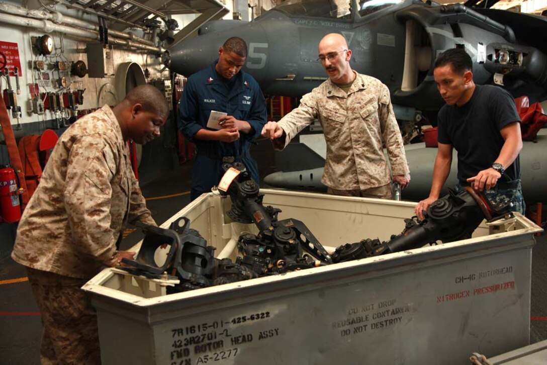 Marines and sailors with the 15th Marine Expeditionary Unit and Peleliu Amphibious Ready Group, inspect a helicopter rotor head in the hangar bay of the USS Peleliu, Jan. 18. The 15th MEU is deployed as part of the Peleliu ARG as a U.S. Central Command theater reserve force, providing support for maritime security operations and theater security cooperation efforts in the U.S. 5th Fleet area of responsibility. (U.S. Marine Corps photo by Cpl. John Robbart III)