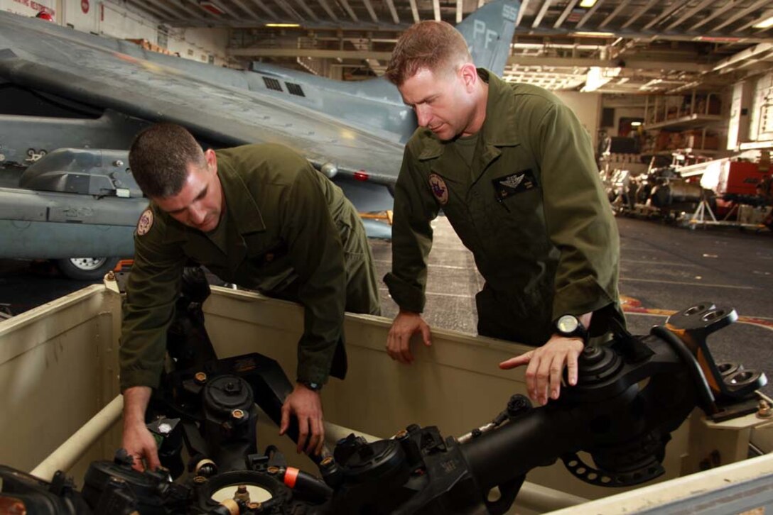 Staff Sgt. Joshua S. Durnell (left), flightline staff non-commissioned officer-in-charge, and Master Sgt. Greg Young, maintenance control chief, both with Marine Medium Helicopter Squadron 364 (Rein.), 15th Marine Expeditionary Unit, inspect a helicopter rotor head in the hangar bay of the USS Peleliu, Jan. 18. The 15th MEU is deployed as part of the Peleliu Amphibious Ready Group as a U.S. Central Command theater reserve force, providing support for maritime security operations and theater security cooperation efforts in the U.S. 5th Fleet area of responsibility. Durnell, 31, is from Ft. Wayne, Ind., and Young, 39, is from Bagdad, Ky. (U.S. Marine Corps photo by Cpl. John Robbart III)