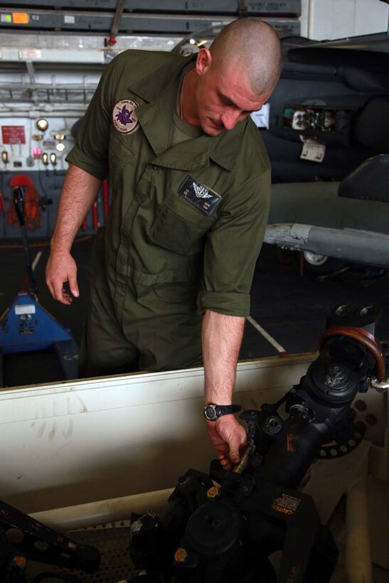 Sgt. Justin D. Smith, CH-46E Sea Knight mechanic, Marine Medium Helicopter Squadron 364 (Rein.), 15th Marine Expeditionary Unit, inspects a helicopter rotor head in the hangar bay of the USS Peleliu, Jan. 18. The 15th MEU is deployed as part of the Peleliu Amphibious Ready Group as a U.S. Central Command theater reserve force, providing support for maritime security operations and theater security cooperation efforts in the U.S. 5th Fleet area of responsibility. Smith, 25, is from Westville, Okla. (U.S. Marine Corps photo by Cpl. John Robbart III)