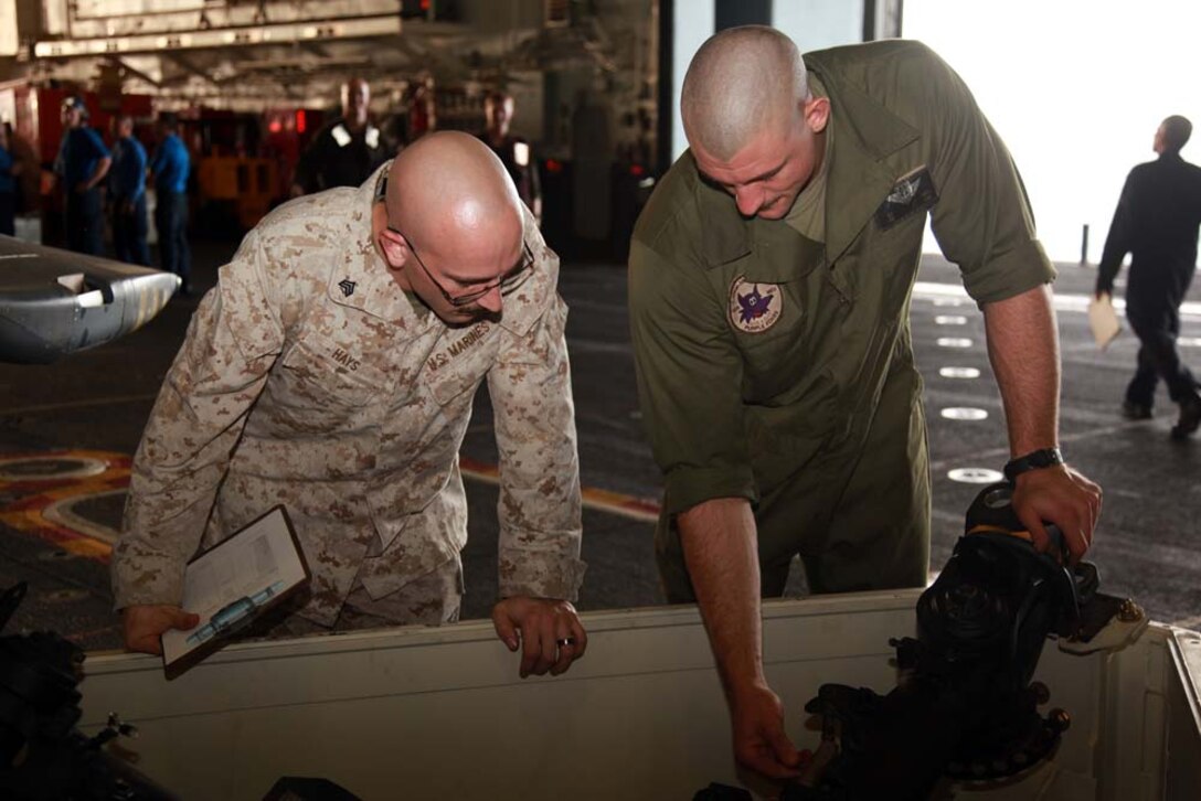 Sgts. David G. Hays (left), dynamic component helicopter mechanic, and Justin D. Smith, CH-46E Sea Knight mechanic, both with Marine Medium Helicopter Squadron 364 (Rein.), 15th Marine Expeditionary Unit, inspect a helicopter rotor head in the hangar bay of the USS Peleliu, Jan. 18. The 15th MEU is deployed as part of the Peleliu Amphibious Ready Group as a U.S. Central Command theater reserve force, providing support for maritime security operations and theater security cooperation efforts in the U.S. 5th Fleet area of responsibility. Hays, 28, is from Cumberland, Ohio, and Smith, 25, is from Westville, Okla. (U.S. Marine Corps photo by Cpl. John Robbart III)