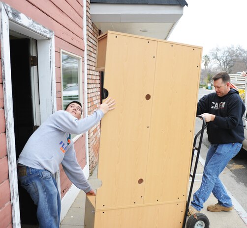 Senior Airman Evan Souther (left), 9th Munitions Squadron munitions controller, and Staff Sgt. Jason Arnold, 9th MUNS assistant NCO in charge of equipment maintenance, maneuver a desk to a new location for the Yuba City Downtown Business Association during a volunteer opportunity in Yuba City Jan. 23, 2013.  In 2012, Beale Airmen participated in more than 200 community outreach events involving 4,962 Airmen in 32 communities.