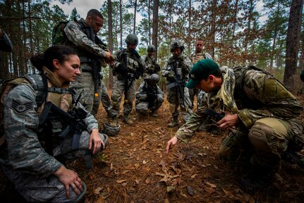 Staff Sgt. Greg Biondo, 1st Combat Camera Squadron photographer, illustrates tactics for a close quarters battle scenario with other Airmen from the 1st CTCS during the Ability to Survive and Operate exercise Jan. 16, 2013, at North Auxiliary Air Field, S.C. Combat Camera held the exercise to train Airmen to function outside the wire as combat documentation specialists. The week-long exercise began Jan. 7 and ended Jan. 18. The 1st CTCS acquires still and motion imagery in support of classified and unclassified air, sea and ground military operations. (U.S. Air Force photo/Senior Airman George Goslin)