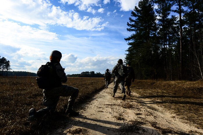 Airmen from the 1st Combat Camera Squadron patrol a road during the Ability to Survive and Operate exercise Jan. 16, 2013, at North Auxiliary Air Field, S.C. Combat Camera held the exercise to train Airmen to function outside the wire as combat documentation specialists. The week-long exercise began Jan. 7 and ended Jan. 18. The 1st CTCS acquires still and motion imagery in support of classified and unclassified air, sea and ground military operations. (U.S. Air Force photo/Senior Airman George Goslin)