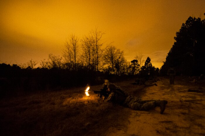 An Airman from the 1st Combat Camera Squadron fires at role-played opposing forces during the Ability to Survive and Operate exercise Jan. 16, 2013, at North Auxiliary Air Field, S.C. Combat Camera held the exercise to train Airmen to function outside the wire as combat documentation specialists. The week-long exercise began Jan. 7 and ended Jan. 18. The 1st CTCS acquires still and motion imagery in support of classified and unclassified air, sea and ground military operations. (U.S. Air Force photo/Senior Airman George Goslin)