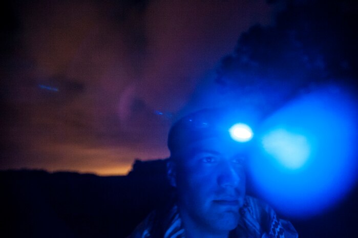 Staff Sgt. David Alderete, 1st Combat Camera Squadron maintainer, uses a light mounted on his helmet to see at night during the Ability to Survive and Operate exercise Jan. 16, 2013, at North Auxiliary Air Field, S.C. Combat Camera held the exercise to train Airmen to function outside the wire as combat documentation specialists. The week-long exercise began Jan. 7, 2013, and ended Jan. 18. The 1st CTCS acquires still and motion imagery in support of classified and unclassified air, sea and ground military operations. (U.S. Air Force photo/Senior Airman Dennis Sloan)