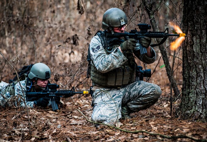 (Right) Senior Airman Matthew Bruch and Senior Airman Jodi Martinez, 1st Combat Camera Squadron photographers, fire at opposing forces during the Ability to Survive and Operate exercise Jan. 16, 2013, at North Auxiliary Air Field, S.C. Combat Camera held the exercise to train Airmen to function outside the wire as combat documentation specialists. The week-long exercise began Jan. 7, 2013, and ended Jan. 18. The 1st CTCS acquires still and motion imagery in support of classified and unclassified air, sea and ground military operations. (U.S. Air Force photo/Senior Airman Dennis Sloan)