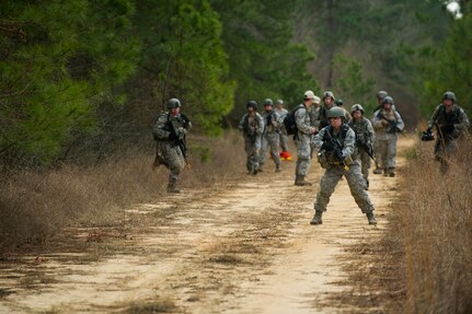 Airmen from the 1st Combat Camera Squadron patrol a road during the Ability to Survive and Operate exercise Jan. 16, 2013, at North Auxiliary Air Field, S.C. Combat Camera held the exercise to train Airmen to function outside the wire as combat documentation specialists. The week-long exercise began Jan. 7 and ended Jan. 18. The 1st CTCS acquires still and motion imagery in support of classified and unclassified air, sea and ground military operations. (U.S. Air Force photo/Senior Airman George Goslin)