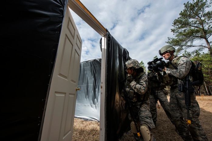 Senior Master Sgt. Elizabeth Carty, 1st Combat Camera Squadron combat photographer, and Airman 1st Class Eric Mann, 1st CTCS broadcaster, form up before clearing a room during the Ability to Survive and Operate exercise Jan. 16, 2013, at North Auxiliary Air Field, S.C. Combat Camera held the exercise to train Airmen to function outside the wire as combat documentation specialists. The week-long exercise began Jan. 7 and ended Jan. 18. The 1st CTCS acquires still and motion imagery in support of classified and unclassified air, sea and ground military operations. (U.S. Air Force photo/Senior Airman George Goslin)