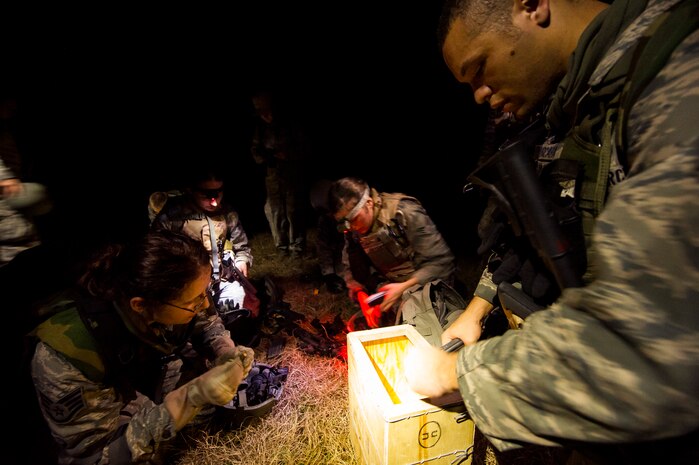 Airmen from the 1st Combat Camera Squadron unload ammunition from magazines during the Ability to Survive and Operate exercise Jan. 16, 2013, at North Auxiliary Air Field, S.C. Combat Camera held the exercise to train Airmen to function outside the wire as combat documentation specialists. The week-long exercise began Jan. 7 and ended Jan. 18. The 1st CTCS acquires still and motion imagery in support of classified and unclassified air, sea and ground military operations. (U.S. Air Force photo/Senior Airman George Goslin)