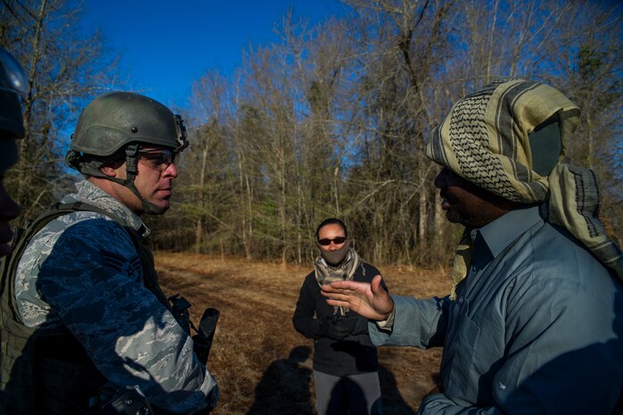 Staff Sgt. David Bertles, 1st Combat Camera Squadron broadcaster, talks with Master Sgt. Thomas Coney, 1st CTCS photographer, during the Ability to Survive and Operate exercise Jan. 18, 2013, at North Auxiliary Air Field, S.C. Combat Camera held the exercise to train Airmen to function outside the wire as combat documentation specialists. The week-long exercise began Jan. 7 and ended Jan. 18. The 1st CTCS acquires still and motion imagery in support of classified and unclassified air, sea and ground military operations. (U.S. Air Force photo/Senior Airman George Goslin)