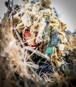Staff Sgt. Samuel Weaver, 1st Combat Camera Squadron maintainer, waits in the grass for opposing forces role players, during the Ability to Survive and Operate exercise Jan. 16, 2013, at North Auxiliary Air Field, S.C. Combat Camera held the exercise to train Airmen to function outside the wire as combat documentation specialists. The week-long exercise began Jan. 7, 2013, and ended Jan. 18. The 1st CTCS acquires still and motion imagery in support of classified and unclassified air, sea and ground military operations. (U.S. Air Force photo/Senior Airman Dennis Sloan)