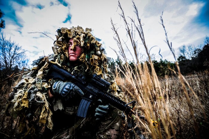 Staff Sgt. Samuel Weaver, 1st Combat Camera Squadron maintainer, waits in the grass for opposing forces role players, during the Ability to Survive and Operate exercise Jan. 16, 2013, at North Auxiliary Air Field, S.C. Combat Camera held the exercise to train Airmen to function outside the wire as combat documentation specialists. The week-long exercise began Jan. 7, 2013, and ended Jan. 18. The 1st CTCS acquires still and motion imagery in support of classified and unclassified air, sea and ground military operations. (U.S. Air Force photo/Senior Airman Dennis Sloan)