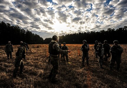 Staff Sgt. Greg Biondo, 1st Combat Camera Squadron photographer, speaks to Airmen about team tactical movements during the Ability to Survive and Operate exercise Jan. 16, 2013, at North Auxiliary Air Field, S.C. Combat Camera held the exercise to train Airmen to function outside the wire as combat documentation specialists. The week-long exercise began Jan. 7 and ended Jan. 18. The 1st CTCS acquires still and motion imagery in support of classified and unclassified air, sea and ground military operations. (U.S. Air Force photo/Senior Airman Dennis Sloan)
