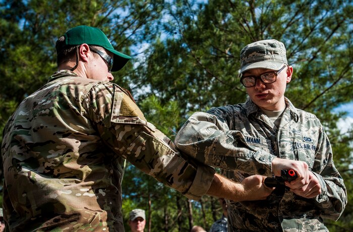 Airman 1st Class Eric Mann, 1st Combat Camera Squadron broadcaster, disarms a Survival, Evasion, Resistance and Escape instructor during the Ability to Survive and Operate exercise Jan. 14, 2013, at North Auxiliary Air Field, S.C. The 1st CTCS held the exercise to train Airmen to function outside the wire as combat documentation specialists. The week-long exercise began Jan. 7 and ended Jan. 18. The 1st CTCS acquires still and motion imagery in support of classified and unclassified air, sea and ground military operations. (U.S. Air Force photo/Senior Airman Dennis Sloan)
