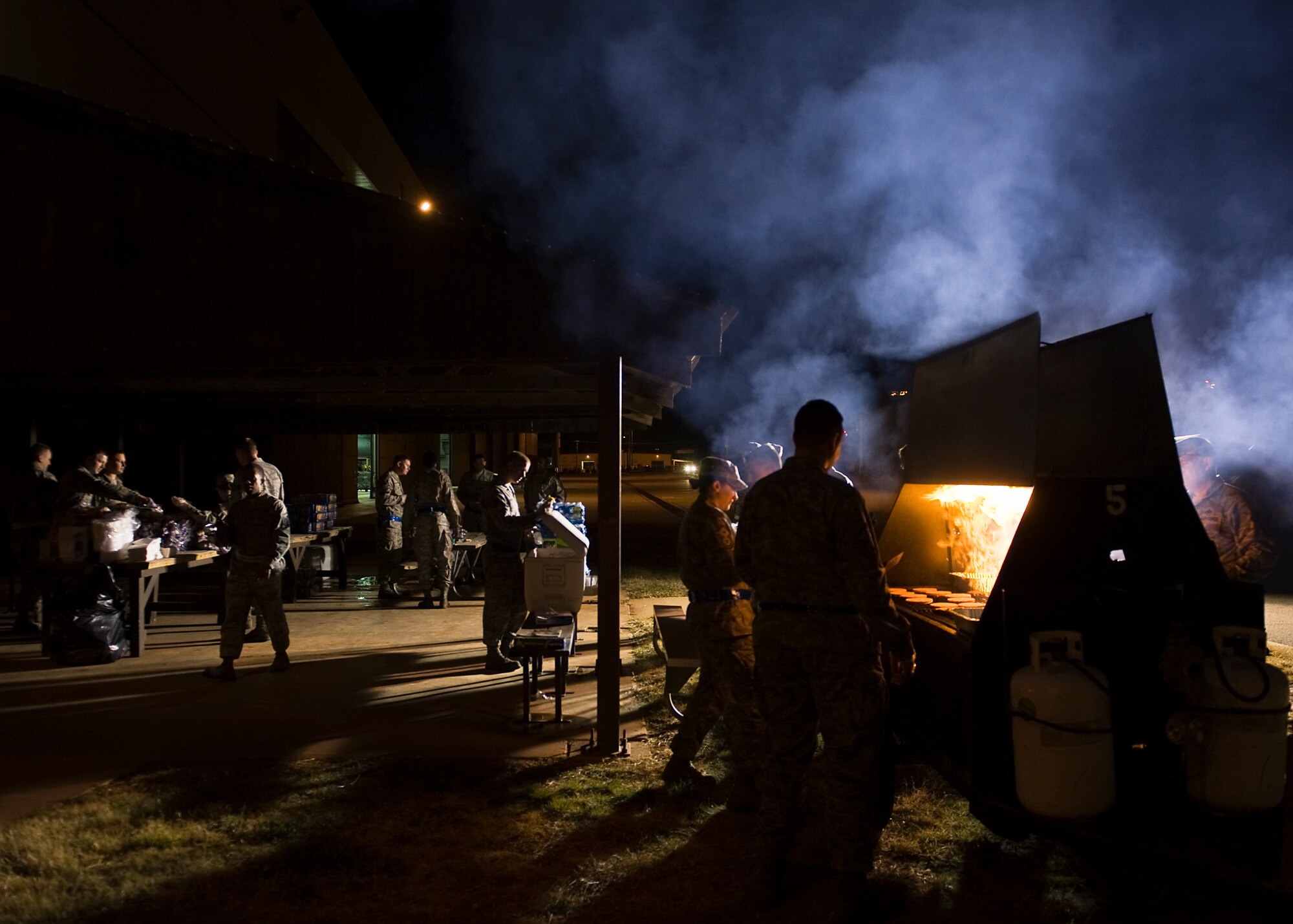 Dyess servicemembers gather outside the 3-Bay Hanger during a midnight barbecue Jan. 24, 2013, at Dyess Air Force Base, Texas. The barbecue was held by the Dyess first sergeant’s group to congratulate swing and mid-shift for personnel on the “Excellent” grade earned during the Consolidated Unit Inspection held Jan. 13-18.(U.S. Air Force photo by Airman 1st Class Damon Kasberg/ Released)
