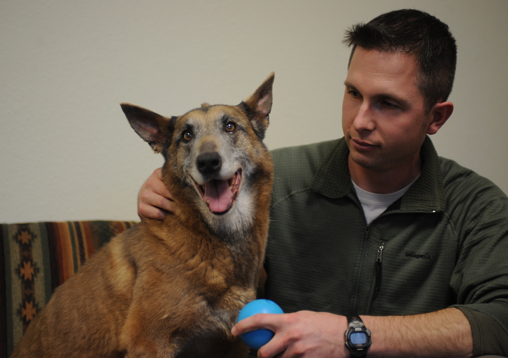 U.S. Air Force Staff Sgt. Robert Wilson, 366th Security Forces Squadron military working dog handler, and Tanja sit on a couch and play with a blue ball Jan. 18, 2013, at Mountain Home Air Force Base, Idaho. Wilson was Tanja's handler for more than a year and deployed with her. (U.S. Air Force photo/Senior Airman Benjamin Sutton)