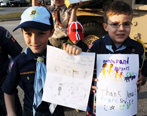 Cub Scouts Ian Sones and Maddox DeMars from Cub Scout Pack 104 of Navarre, Fla., hold up homemade cards for military personnel during their visit to the 23rd Special Tactics Squadron at Hurlburt Field, Fla., Jan. 24, 2013. Six Cub Scouts donated $760 worth of popcorn to Airmen on behalf of Pack 104. The Scouts were given the opportunity to explore a Humvee and witness combat controllers rappel as a token of appreciation. (U.S. Air Force photo/Rachel Arroyo) 

