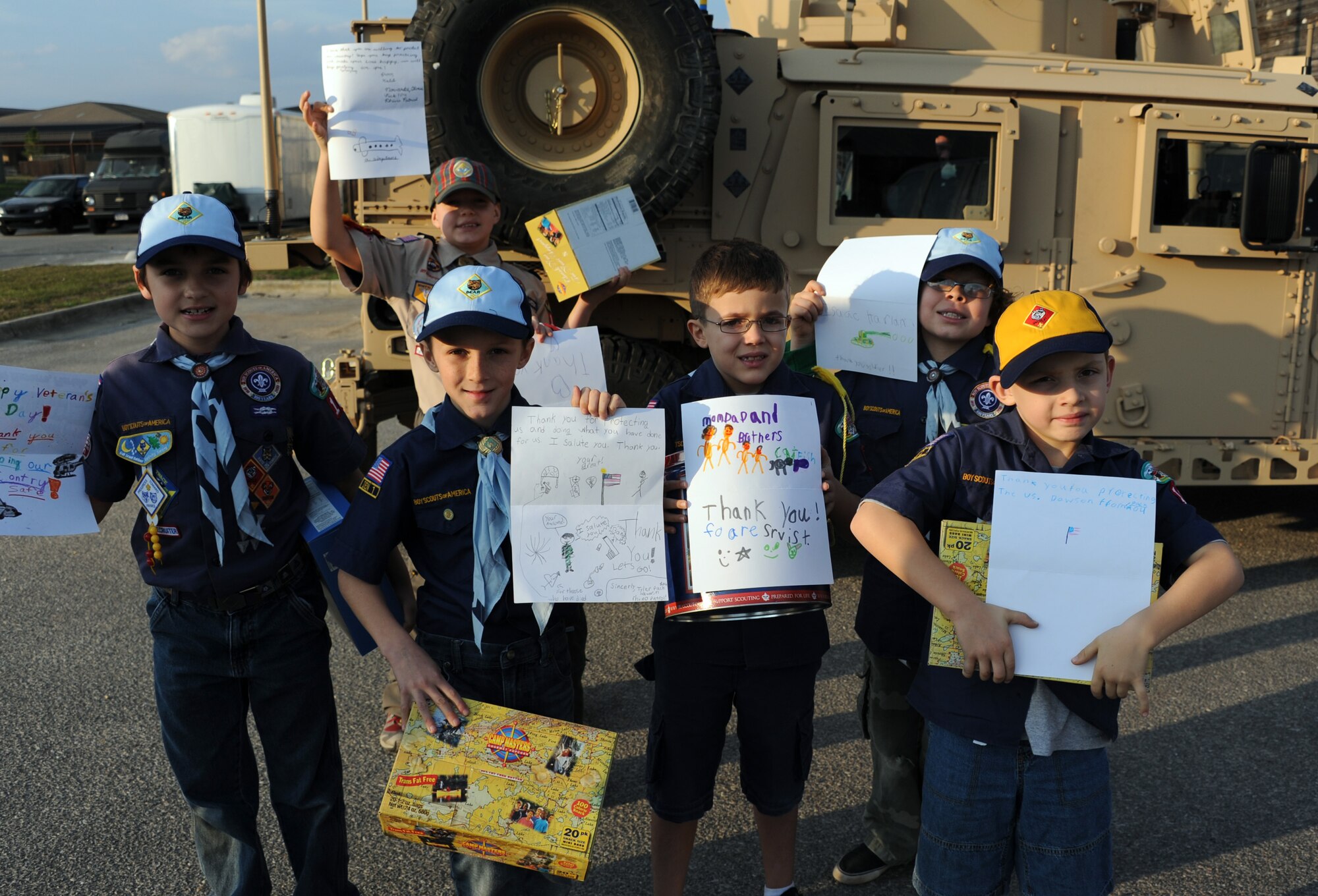 Boy Scouts from Cub Scout Pack 104 of Navarre, Fla., hold up homemade cards for military personnel during their visit to the 23rd Special Tactics Squadron at Hurlburt Field, Fla., Jan. 24, 2013. Six Boy Scouts of America donated $760 worth of popcorn to Airmen on behalf of Pack 104. The Scouts were given the opportunity to explore a Humvee and witness combat controls rappel as a token of appreciation. (U.S. Air Force photo/Rachel Arroyo)