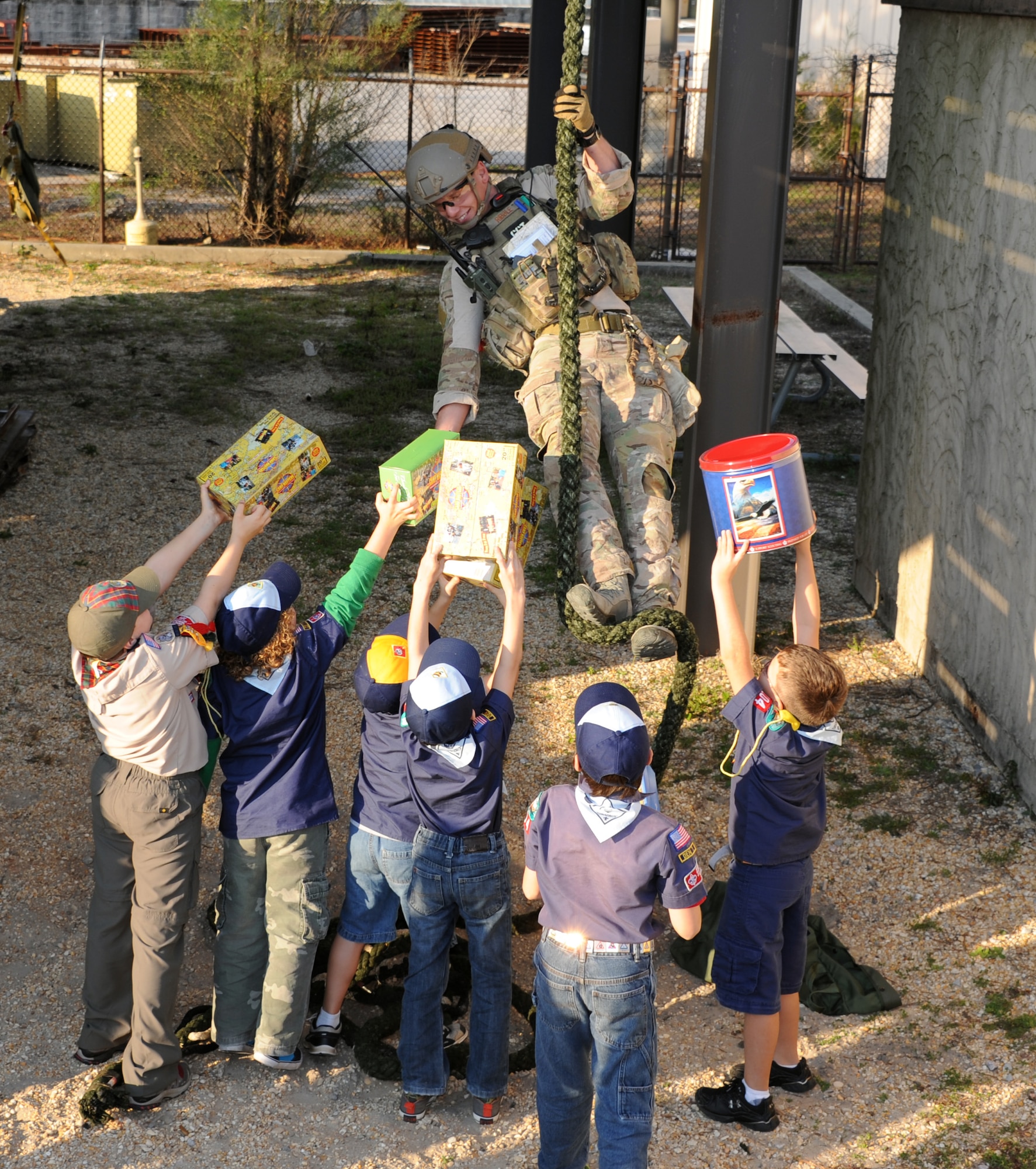 Boy Scouts from Cub Scout Pack 104 of Navarre, Fla., pass popcorn to a combat controller during their visit to the 23rd Special Tactics Squadron at Hurlburt Field, Fla., Jan. 24, 2013. Six Boy Scouts of America donated $760 worth of popcorn to Airmen on behalf of Pack 104. The Scouts were given the opportunity to explore a Humvee and witness combat controls rappel as a token of appreciation. (U.S. Air Force photo/Rachel Arroyo)