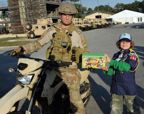 Cub Scout Isaac Harlan passes a box of popcorn to Senior Airman Jesse Maierhoffer during Cub Scout Pack 104's visit to Hurlburt Field, Fla., Jan. 24, 2013. Six Cub Scounts donated $760 worth of popcorn to Airmen on behalf of Pack 104. (U.S. Air Force photo/Rachel Arroyo) 

