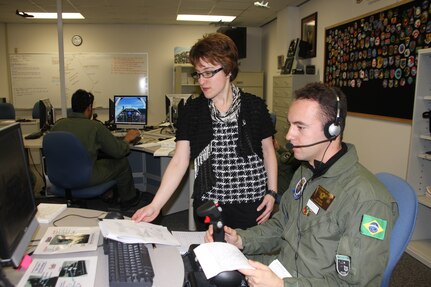 Sarah Hodge, Defense Language Institute-English Language Center's lead aviation English curriculum developer, conducts a flying exercise in the
Simulator Lab with Lt. j.g. Anderson Spedini De Oliveira of the Brazilian Navy. Spedini is currently attending the English Language Skills for Communication Course at DLI-ELC. (U.S. Air Force Photo/Annette Janetzke)
