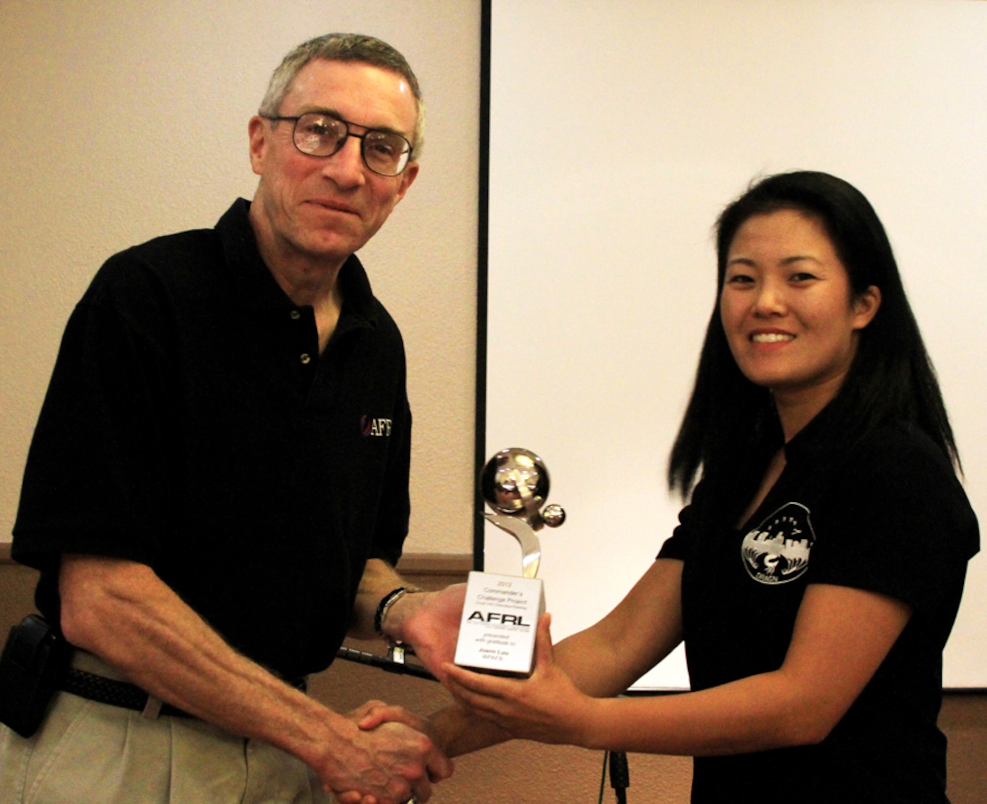 Joann Luu accepts her individual trophy from Maj. Gen. William McCasland, Air Force Research Laboratory commander, after her Air Force Materiel Command research team won the AFRL Commander’s Challenge. Luu is from the 519th Software Maintenance Squadron at Hill AFB, Utah. (Courtesy photo)