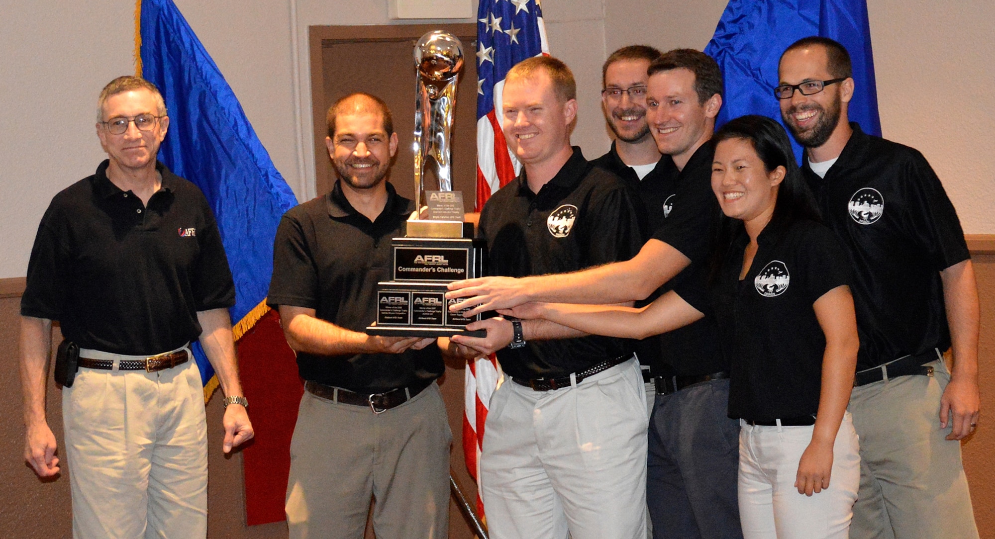 The Commander’s Challenge team from Air Force Materiel Command accepts the first place travelling winning trophy from Maj. Gen. William McCasland, left, Air Force Research Laboratory commander. Team members, from left, are Daniel Gallagher, 1st Lt. Joshua Thomas, James Brewer, Adam Tuxbury, Joann Luu and Robert Merrill. Luu, from the 519th Software Maintenance Squadron at Hill AFB, Utah, was the team’s software lead. (Courtesy photo)