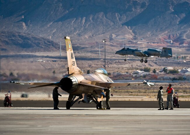 U.S. Air Force Airmen conduct pre-flight checks on a 64th Aggressor Squadron F-16 Fighting Falcon during Red Flag 13-2, Jan. 22, 2013, at Nellis Air Force Base, Nev. The 64 AGRS's mission is to prepare the combat air forces, joint and allied aircrews for tomorrow's victories with challenging and realistic threat replication, training, academics and feedback. (U.S. Air Force photo/Senior Airman Brett Clashman)