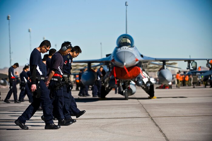 Republic of Singapore Air Force assigned to the 425th Fighter Squadron at Luke Air Force Base, Ariz., conduct a foreign object debris check during Red Flag 13-2, Jan. 22, 2013, at Nellis Air Force Base, Nev. The squadron's current mission is to provide advanced weapons and tactics continuation training for Republic of Singapore Air Force F-16 Fighting Falcon pilots and maintenance personnel. (U.S. Air Force photo/Senior Airman Brett Clashman)