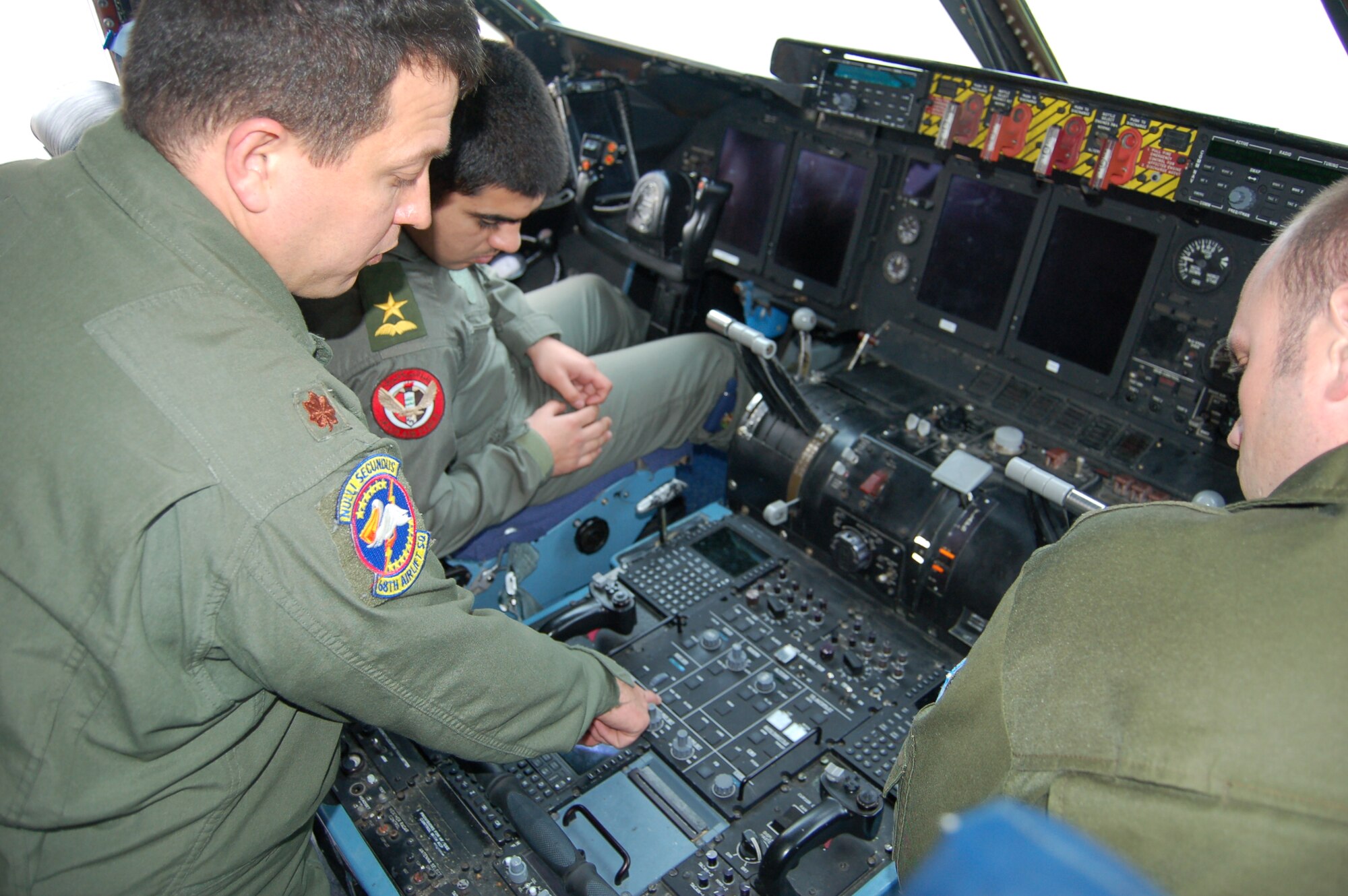Maj. Chris Melton, center, a C-5A Galaxy pilot assigned to the 68th Airlift Squadron, explains the jet’s complex digital navigation panel, to two pilots from Iraq (left) and Ukraine (right).  Both pilots are students from the Defense Language Institute Foreign Language Center on Joint Base San Antonio-Lackland.  Both foreign pilots visited the “Alamo Wing” on Jan. 24 to learn about real-world C-5 Galaxy flying from actual C-5 pilots.  The 68th Airlift Squadron is one of two flying squadrons assigned to the 433rd Airlift Wing, a C-5A equipped, Air Force Reserve unit also located on JBSA-Lackland. (U.S. Air Force photo by Elsa Martinez)
