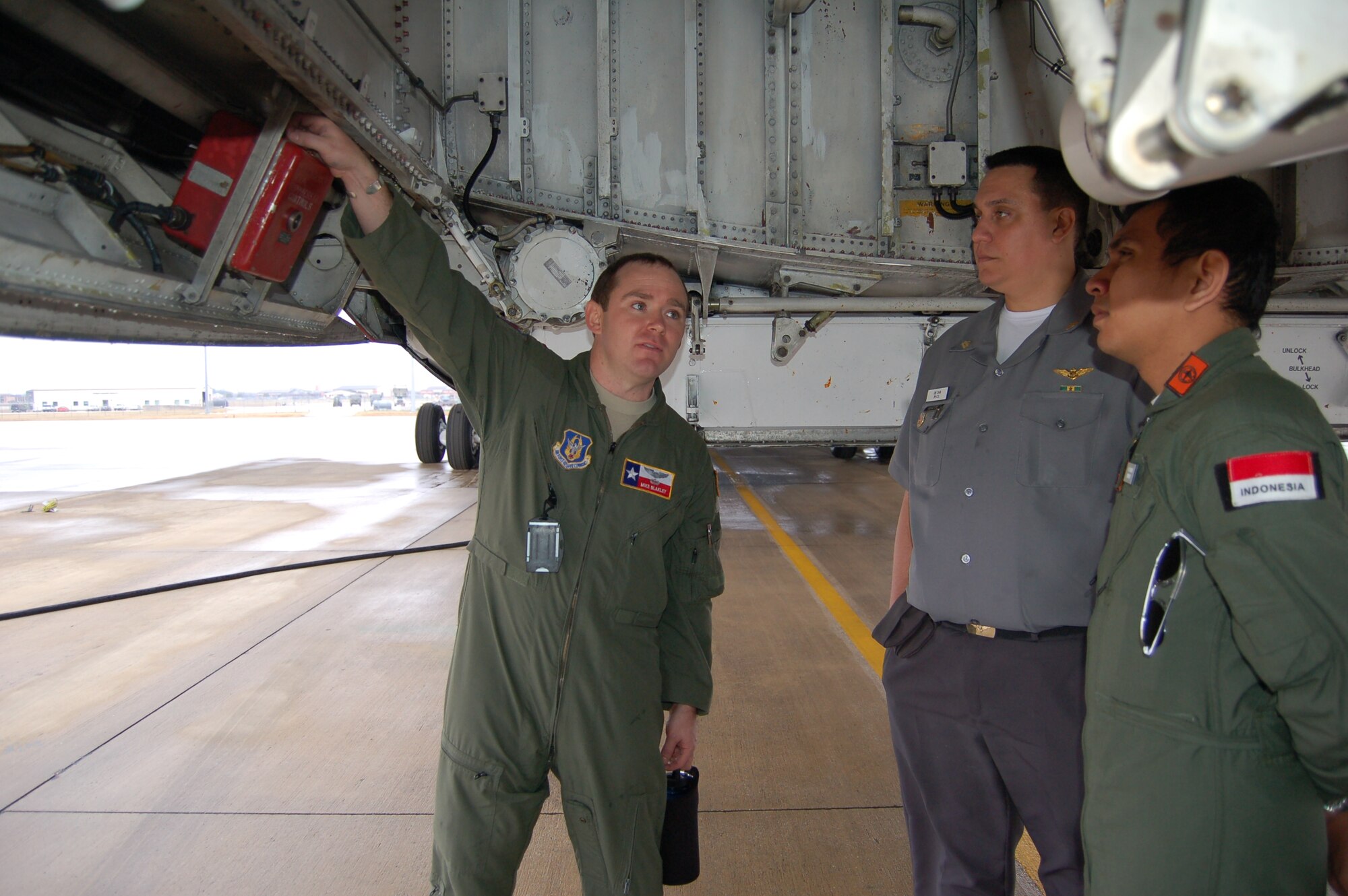 Two pilots from Brazil (center) and Indonesia (right), learn about the fire-suppression control panel on the C-5A Galaxy from 2nd Lt. Mike Blakley. Blakley is a C-5A pilot assigned to the 68th Airlift Squadron, 433rd Airlift Wing. Both pilots are students at the Defense Language Institute Foreign Language Center located on Joint Base San Antonio-Lackland.  Pilots visited the wing to learn more about flying the C-5 from those pilots who actually fly the massive jet.