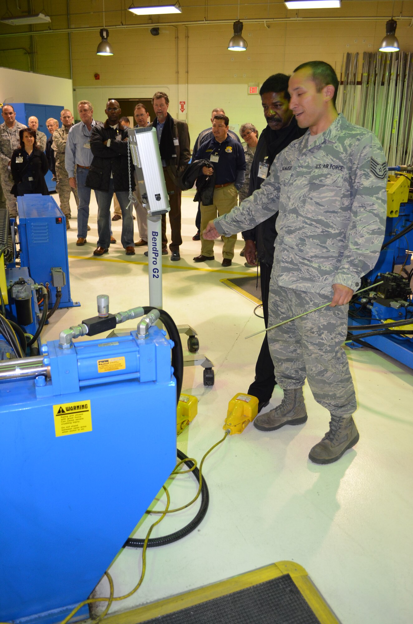 Tech. Sgt. John Gonzalez, a metals technician for the 433rd Structural Repair shop, demonstrates the metal-tubing bender to Otis Scott, an engineering careers counselor for the University of Texas at San Antonio and Honorary Commander for the 26th Aerial Port Squadron at the 433rd Airlift Wing.  The tour was one of eight shop visits made by 15 visiting Honorary Commanders to learn about the wing's maintenance mission and the C-5A Galaxy aircraft.  The Honorary Commanders program partners area civic and business leaders with wing senior leadership to educate them about the wing's mission and its role in the Reserve forces, the U.S. Air Force, and the national defense. (U.S. Air Force Photo/Major Timothy Wade)