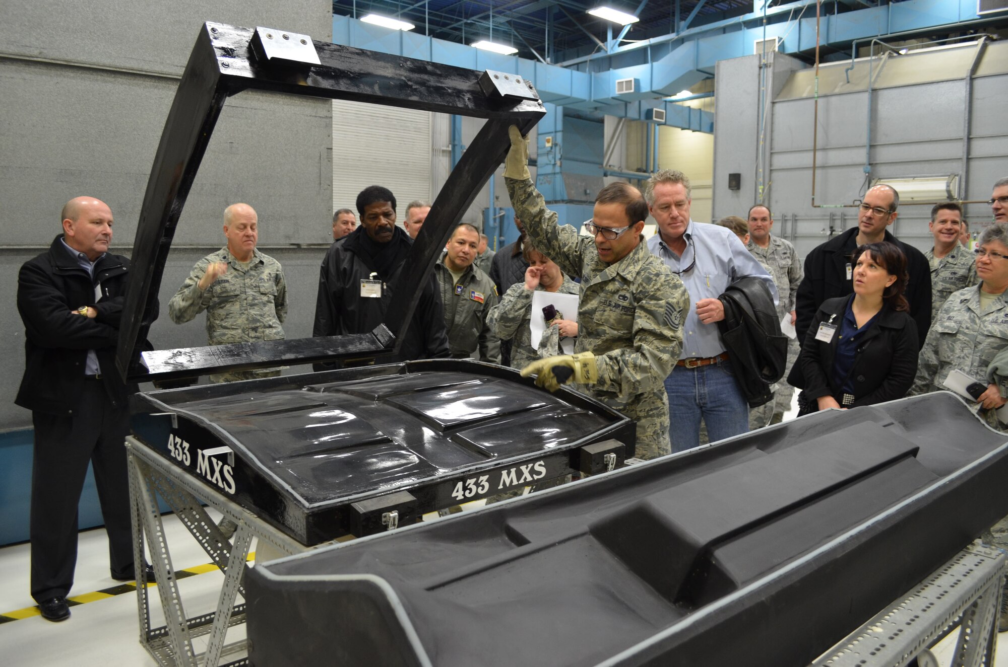 Tech. Sgt. David Alsip, sheet metal mechanic assigned to the 433rd Maintenance Squadron Corrosion Shop, explains the molding machinery that manufactures fiberglass and plastic interior panels for the C-5A Galaxy aircraft assigned to the 433rd Airlift Wing. Fifteen Honorary Commanders visited the Corrosion and other C-5A maintenance shops on Jan. 18, 2013 to learn more about the wing's C-5A maintenance mission.  (U.S. Air Force Photo/Major Timothy Wade)