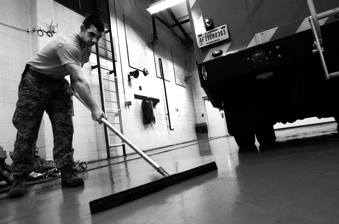 U.S. Air Force Staff Sgt. Derek Dobbins, 633rd Civil Engineer Squadron fire department crew chief, cleans up excess water after servicing and refilling alert vehicles at the fire department on Langley Air Force Base, Va., Jan. 15, 2013. Personnel at Langley’s fire department have 60 seconds to board an alert vehicle, and five minutes to respond on-scene to an incident after receiving an alarm. (U.S. Air Force photo by Staff Sgt. Jeff Nevison/Released)