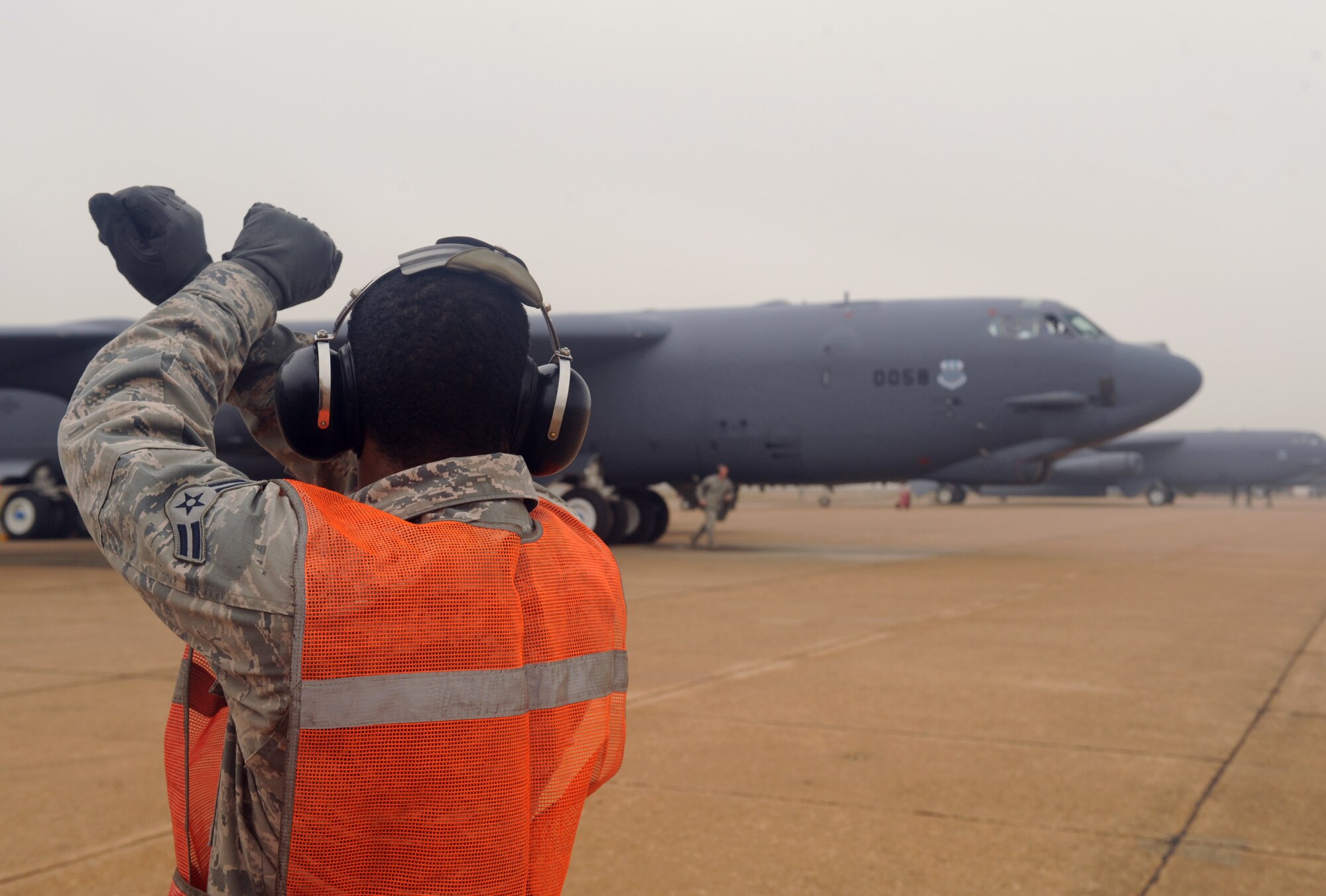 Airman 1st Class Johnny King, 20th Aircraft Maintenance Unit crew chief, marshals a B-52H Stratofortress during a launch on Barksdale Air Force Base, La., Jan. 24. Marshalling is one-on-one visual communication and a part of aircraft ground handling. It is an alternative to radio communications between the aircraft and crew chief to signal when to taxi. (U.S. Air Force photo/Airman 1st Class Benjamin Gonsier)