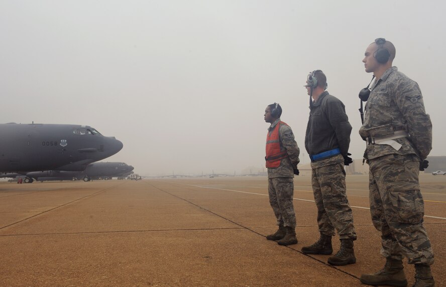 Maintenance Airmen prepare to marshal a B-52H Stratofortress during a launch on Barksdale Air Force Base, La., Jan. 24. Marshalling is one-on-one visual communication and a part of aircraft ground handling. It is an alternative to radio communications between the aircraft and crew chief to signal when to taxi. (U.S. Air Force photo/Airman 1st Class Benjamin Gonsier)
