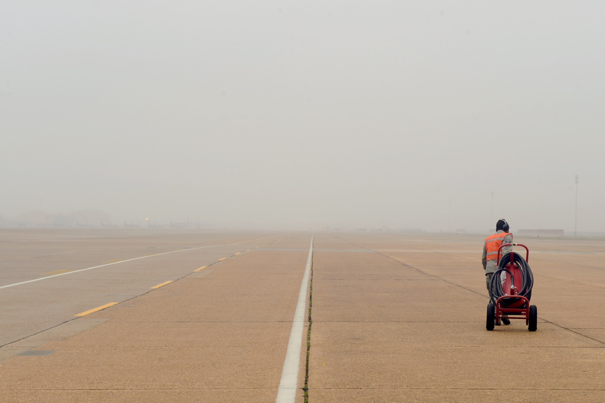 Airman 1st Class Johnny King, 20th Aircraft Maintenance Unit crew chief, moves a dry chemical extinguisher away from a B-52H Stratofortress before launch on Barksdale Air Force Base, La., Jan. 24. A dry chemical extinguisher is always positioned in front of an aircraft in the event of an aircraft fire while still on the ground. (U.S. Air Force photo/Airman 1st Class Benjamin Gonsier)