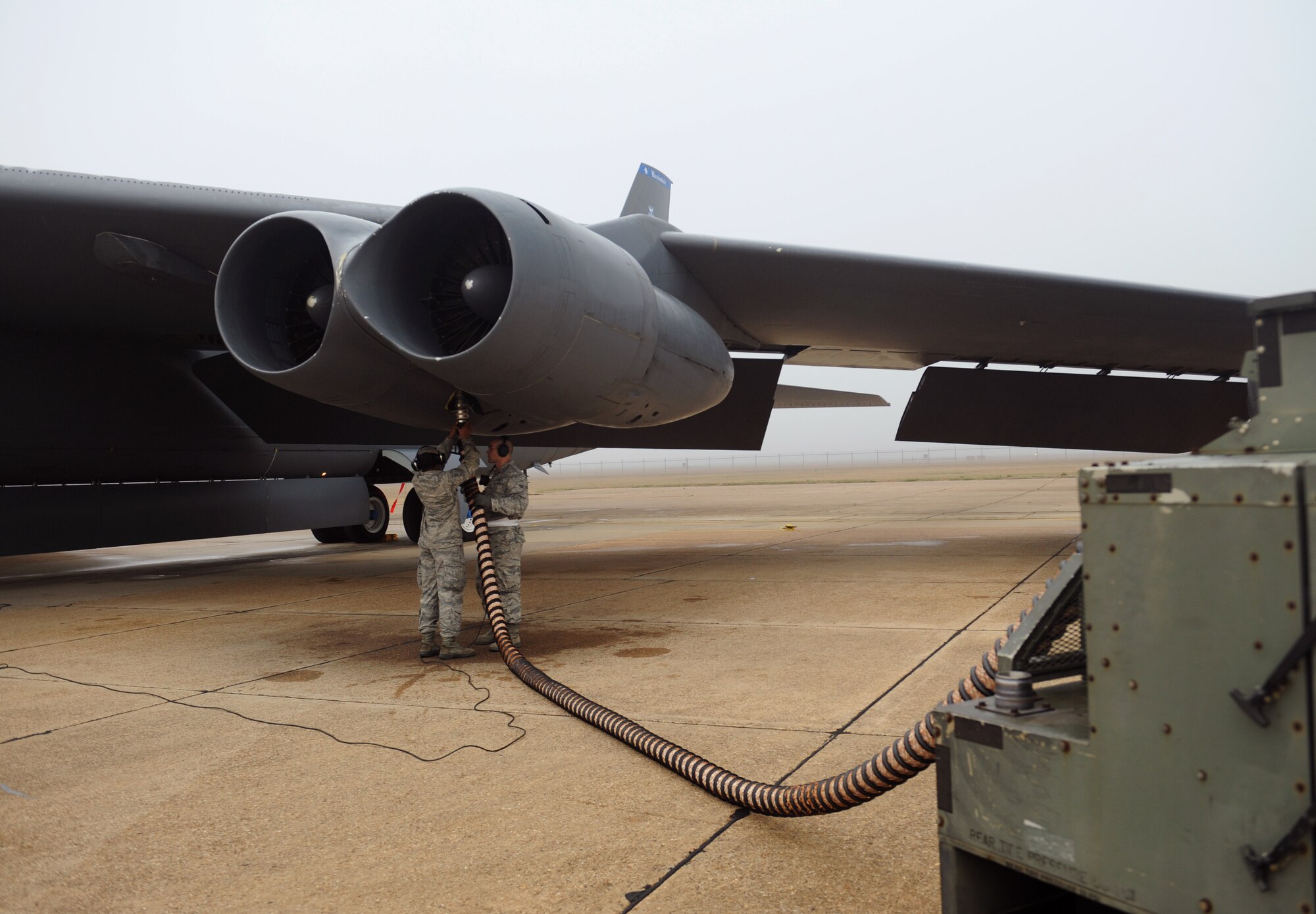 Airmen 1st Class Johnny King, 20th Aircraft Maintenance Unit crew chief, and Austin Smith, 2nd Maintenance Squadron, connect an aircart hose to a B-52H Stratofortress engine on Barksdale Air Force Base, La., Jan. 24. The aircart is used to start one engine which in turn starts the rest of the engines on the aircraft. (U.S. Air Force photo/Airman 1st Class Benjamin Gonsier)