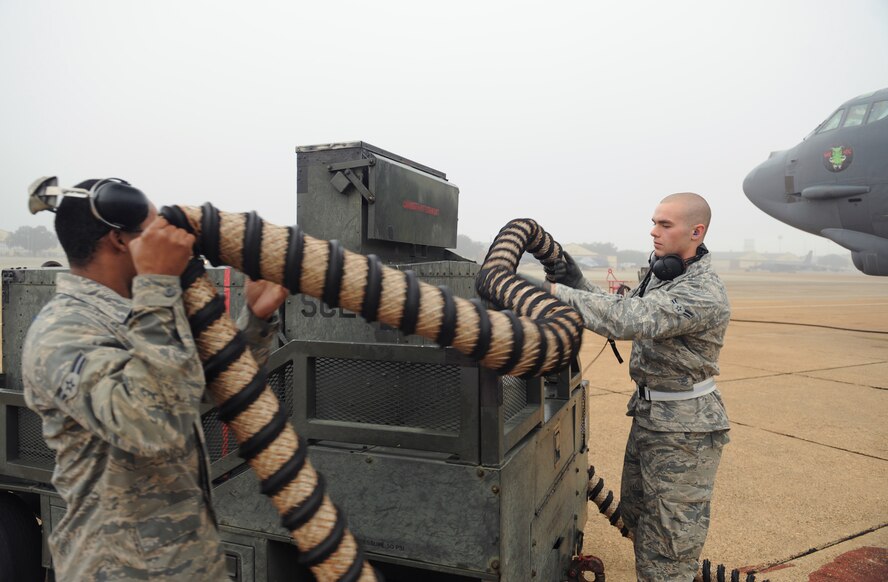 Airmen 1st Class Johnny King, 20th Aircraft Maintenance Unit crew chief, and Austin Smith, 2nd Maintenance Squadron, put an aircart hose away prior to a B-52H Stratofortress launch on Barksdale Air Force Base, La., Jan. 24. After equipment has served its purpose, it is moved so it does not interfere with the launch of the aircraft. (U.S. Air Force photo/Airman 1st Class Benjamin Gonsier)