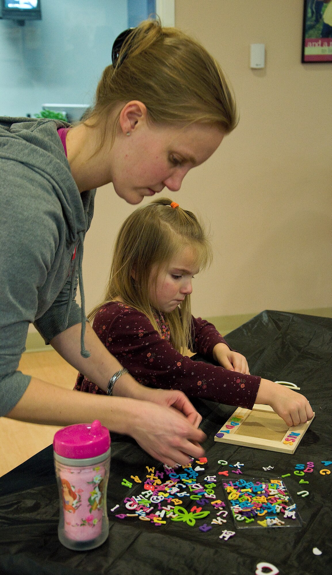 A spouse and her child make a picture frame for their deployed Airmen at a deployed spouses’ dinner on Jan. 17 at the youth center on Dover Air Force Base, Del. The dinner is a free event for families that are separated due to deployment, extended temporary duties, remote tours and projected deployments. (U.S. Air Force photo/Airman 1st Class Ashlin Federick)