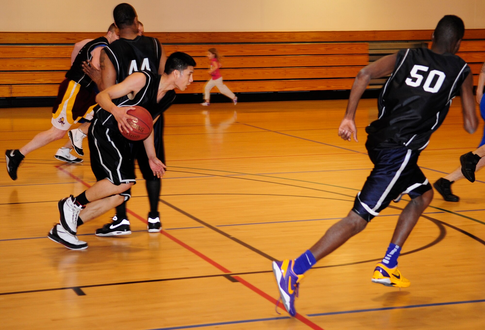 Senior Airman Wivlan Tan, 100th Maintenance Squadron electrical environmental aircraft journeyman, drives the ball up the court during an intramural basketball game between the 100th Maintenance Group and the 100th Maintenance Operations Squadron Jan. 24, 2013, at the Hardstand Fitness Center on RAF Mildenhall, England. The 100th MXG was victorious over the 100th MOS with a final score of 54-28. (U.S. Air Force photo by Airman 1st Class Dillon Johnston/Released)