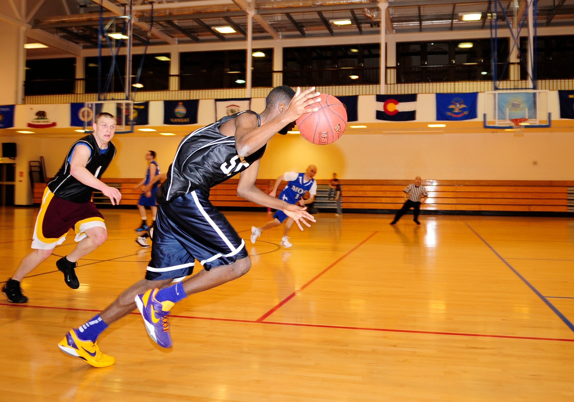 Airman 1st Class Jarvis Tinsley, 100th Maintenance Squadron fuels systems apprentice, drives the ball up the court during an intramural basketball game between the 100th Maintenance Group and the 100th Maintenance Operations Squadron Jan. 24, 2013, at the Hardstand Fitness Center on RAF Mildenhall, England. The 100th MXG was victorious over the 100th MOS with a final score of 54-28. (U.S. Air Force photo by Airman 1st Class Dillon Johnston/Released)