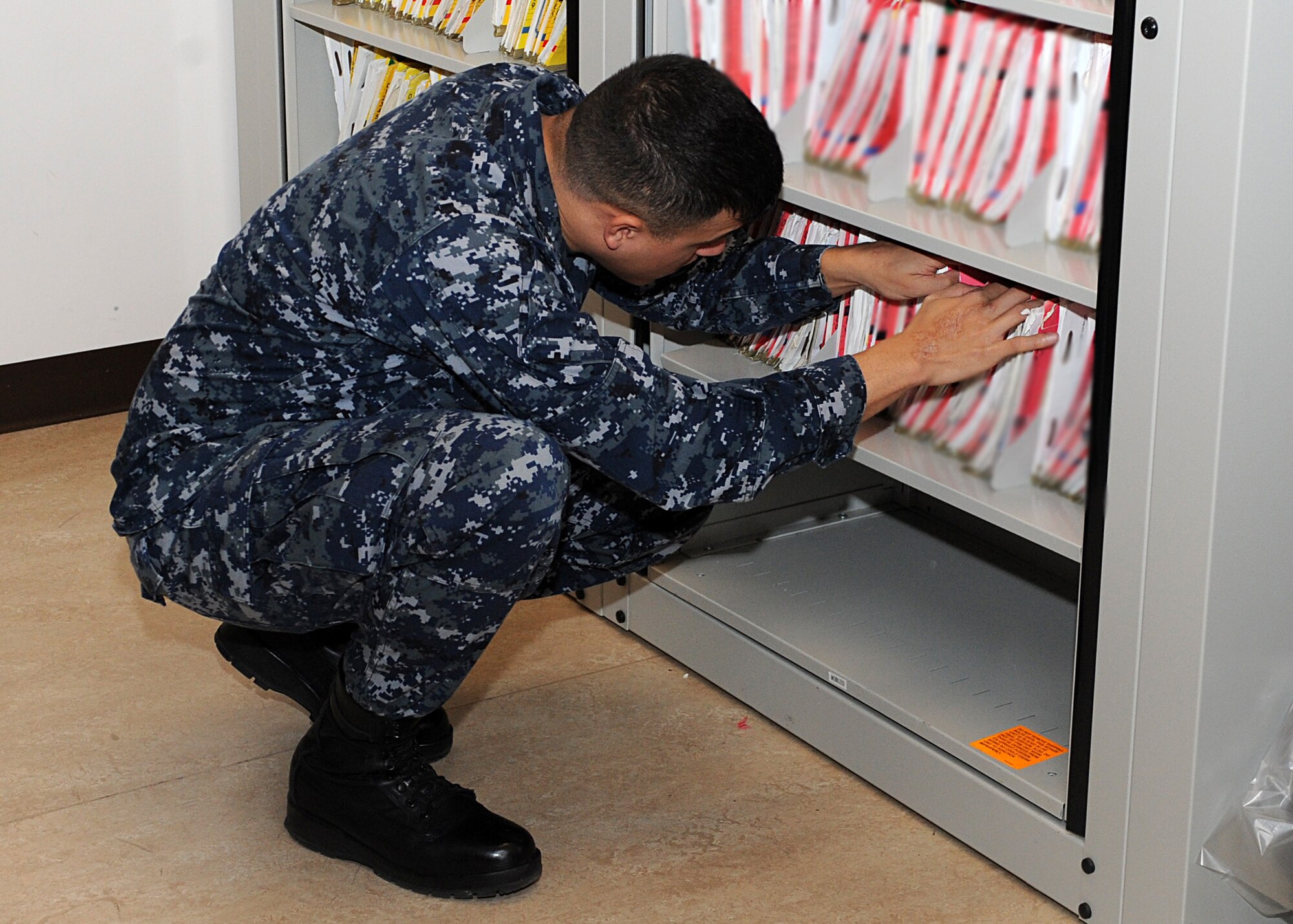 Petty Officer 1st Class Ruben Leyvaa, Navy Operatons Support Center hospital corpsman, searches for a medical record Jan. 16 in the medical records vault on Luke Air Force Base. The NOSC has a medical unit for Navy reservists to visit on reserve weekends to attend to medical issues. (U.S. Air Force photo/Airman 1st Class Devante Williams)