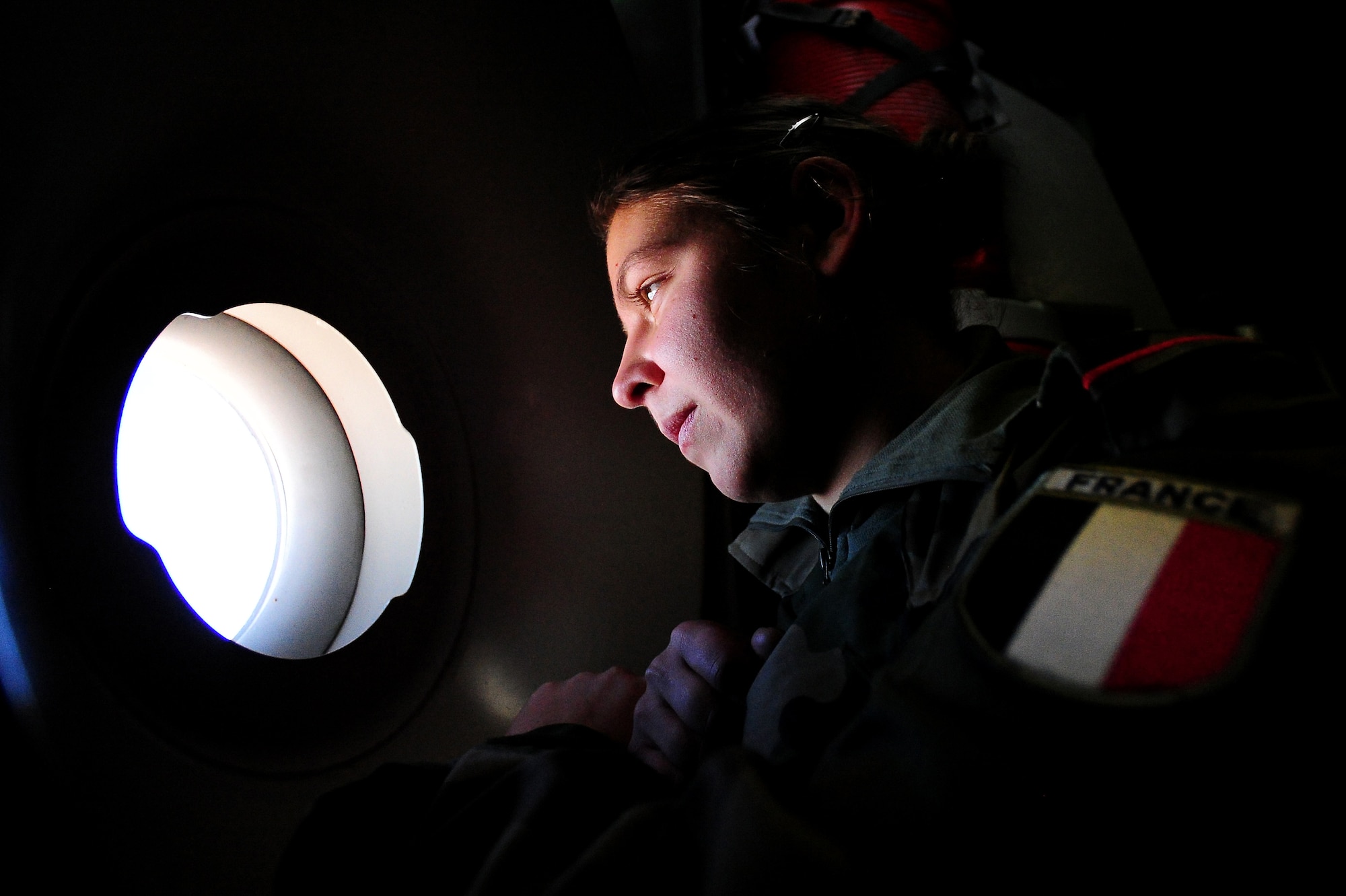 WESTERN EUROPE - French soldier, Marjorie Moreaux, looks out of a window while in route to Mali in a U.S. Air Force C-17 Globemaster III. The United States has agreed to help France airlift troops and equipment into Mali. (U.S. Air Force photo by Senior Airman James Richardson/Released)